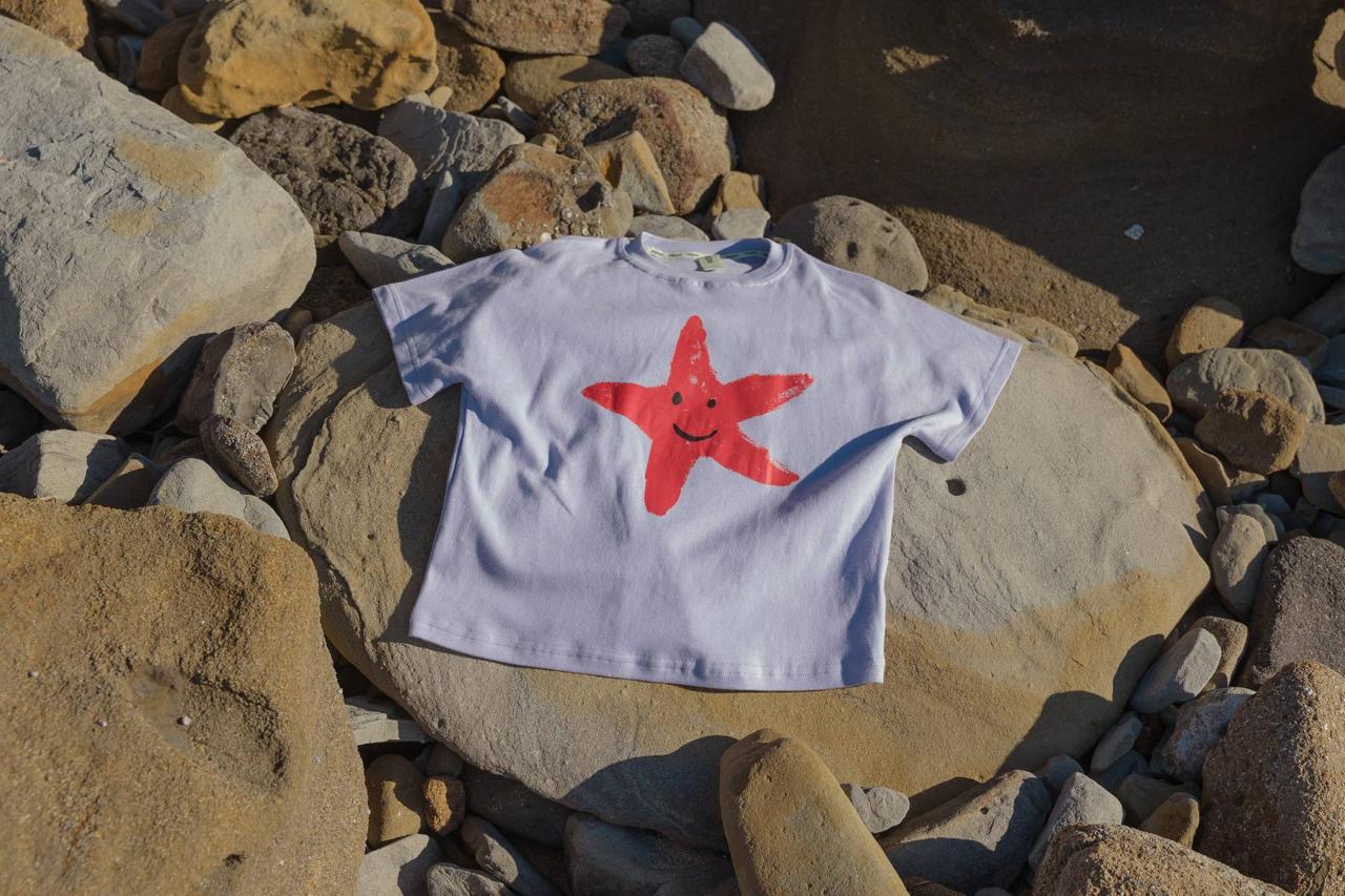 Starfish Tee Crop Purple - flat lay front view on rocks