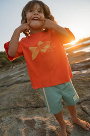 Big Glub Tee - boy smiling on rocks with Big Glub Shorts sunset