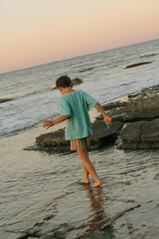 Sea Tee Green - boy playing in ocean sunset