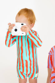 Toddler with Polaroid camera wearing Sea Kelp Aqua Shortie