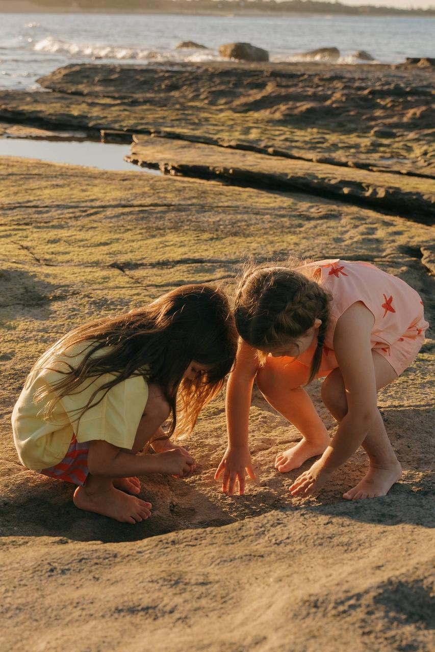 Pipi Shorts - kids exploring rock pools at sunset