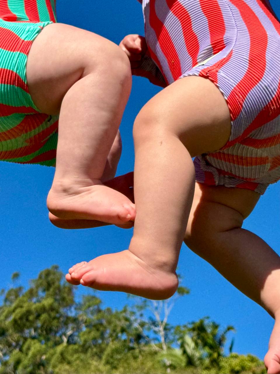 Boy jumping against blue sky wearing Pekpi Sea Kelp Aqua Shortie