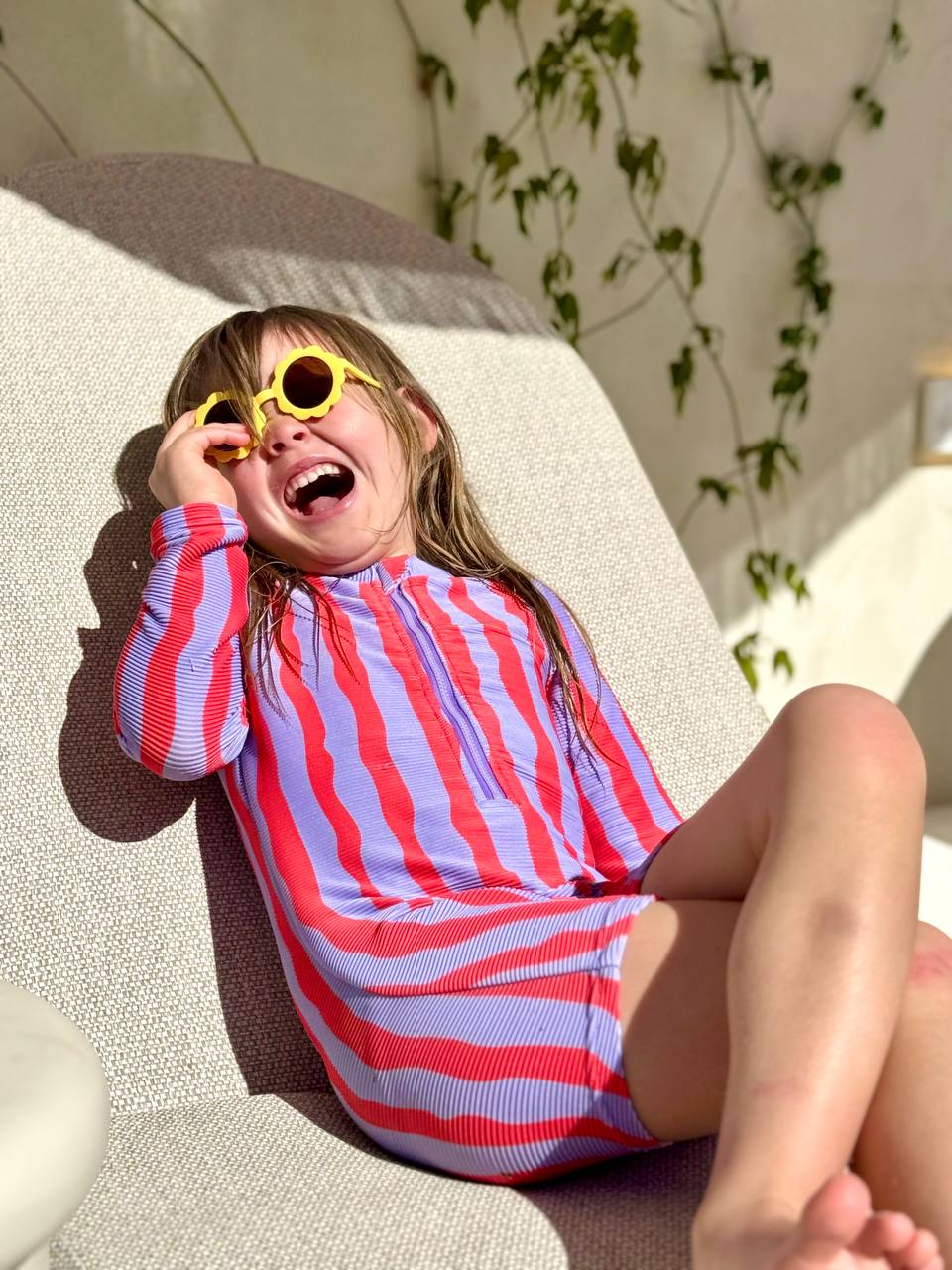 Girl laughing wearing Sea Kelp Pipi Shortie with yellow sunglasses